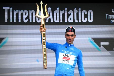 Juan Ayuso holding a golden trident