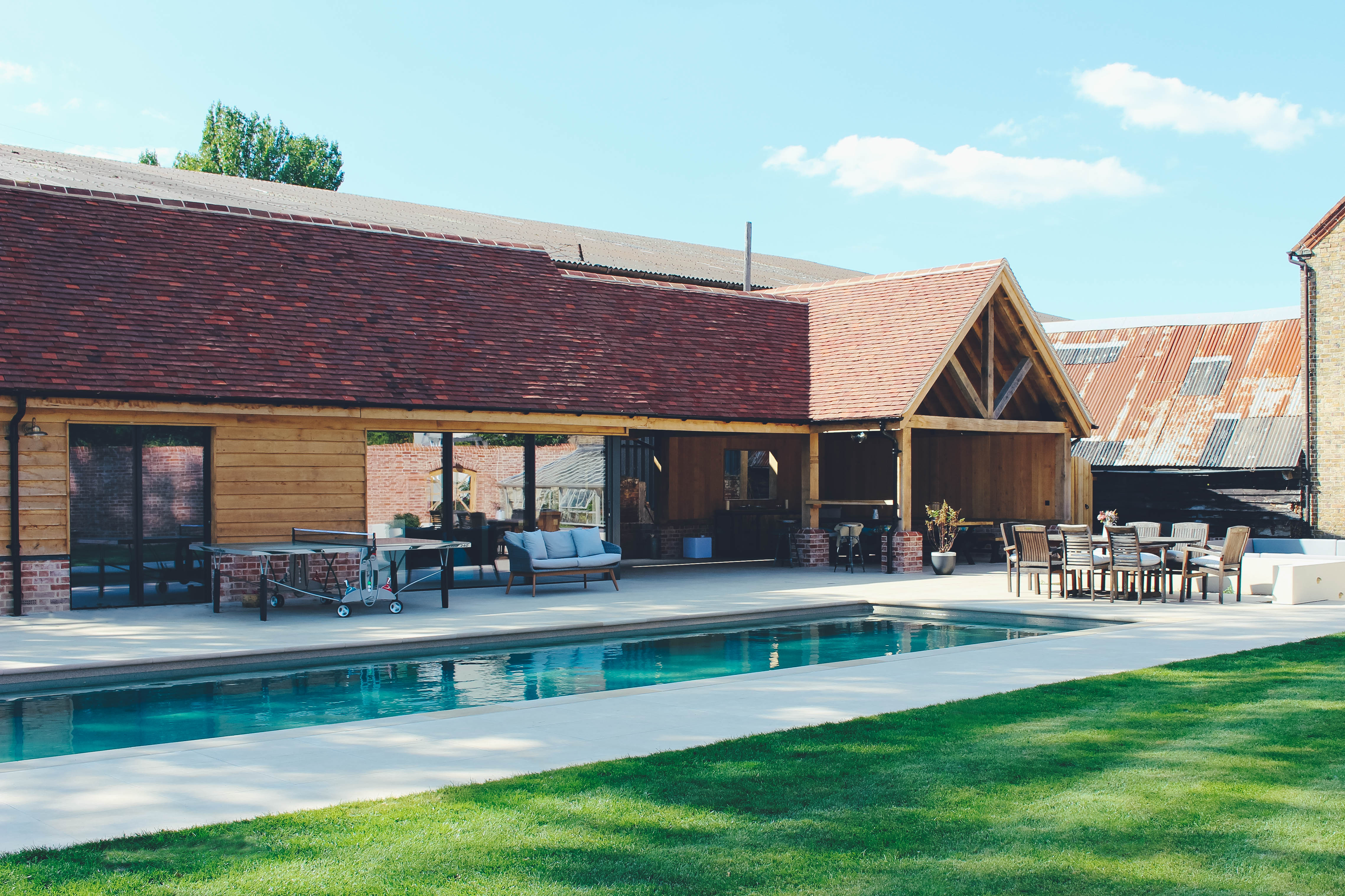 large swimming pool outside home with patio and lawn