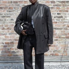 @daniellejinadu wears a leather blazer, white top and black trousers 