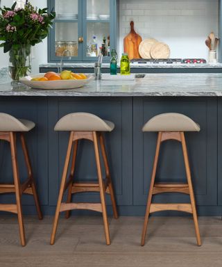 Kitchen with gray cabinets, island and bar stools