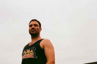 Songwriter William Crighton stands in front of a grey sky