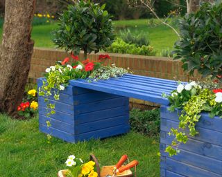 blue painted outdoor bench made from wooden planters and timber slats