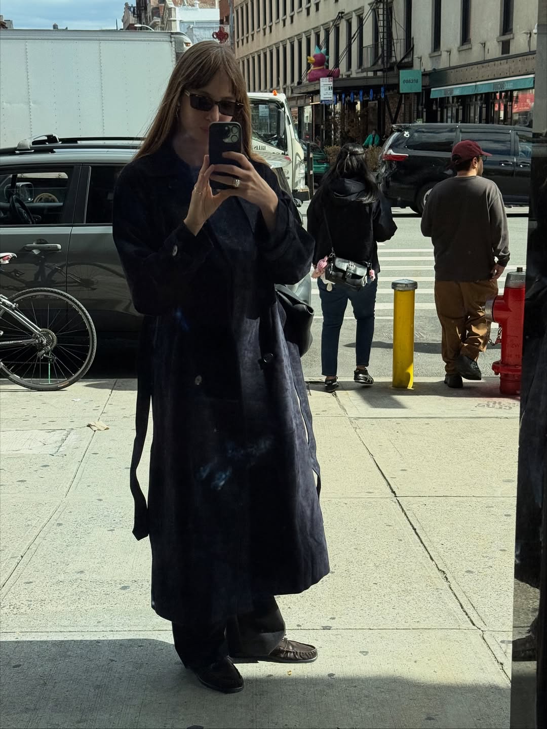 Woman wears navy trench coat, brown trousers and loafers