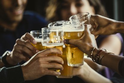 Group of friends toasting beer glasses in a bar