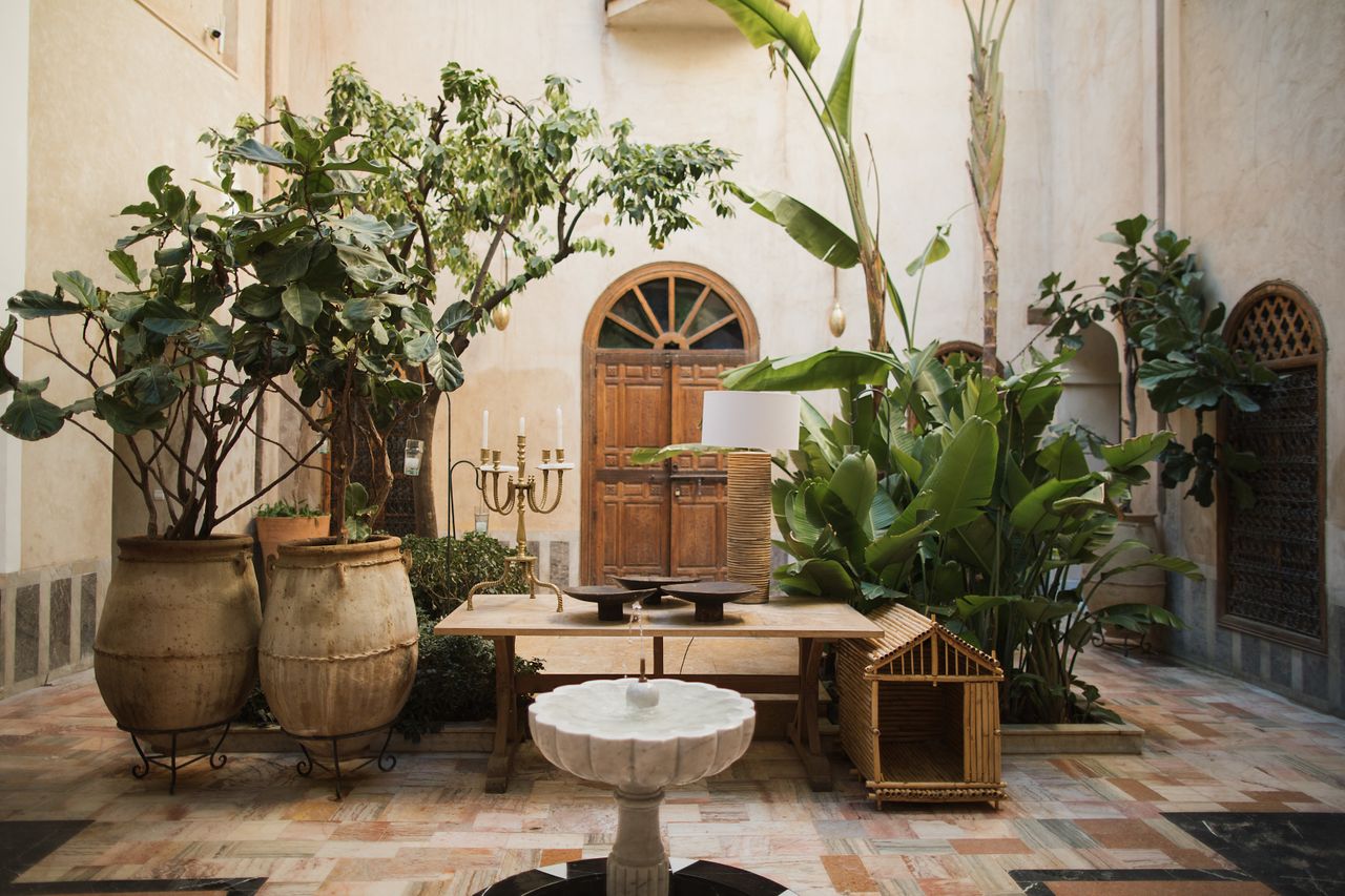 A stone and wood inner courtyard decorated with plants and antiques.