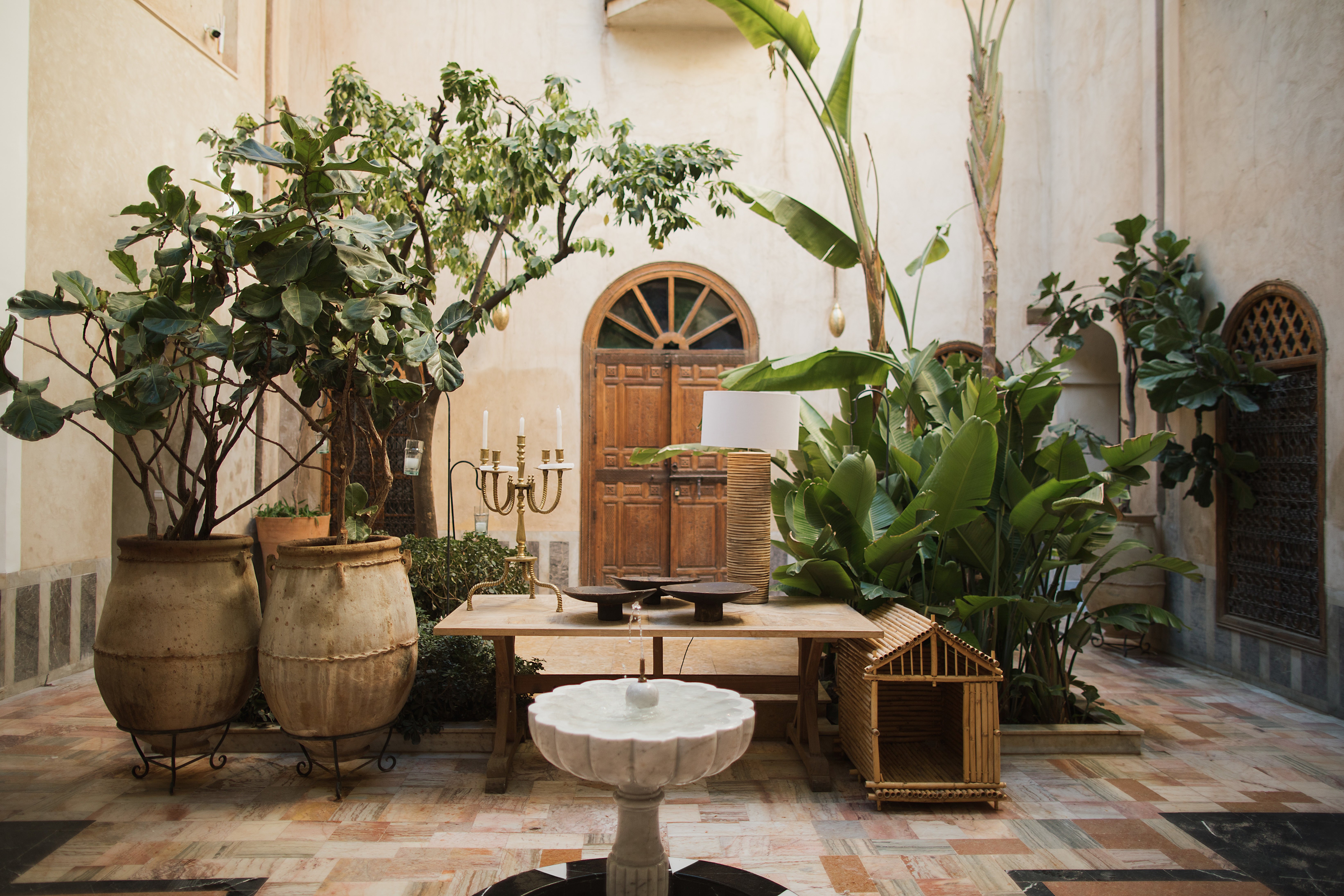 A stone and wood inner courtyard decorated with plants and antiques.