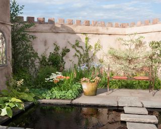small walled garden with stepping stones across pond