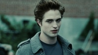 Robert Pattinson as Edward Cullen in peacoat in front of high school in Twilight
