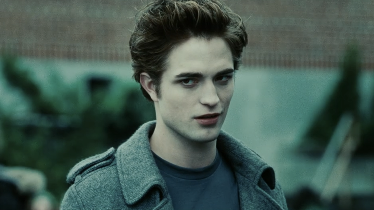 Robert Pattinson as Edward Cullen in peacoat in front of high school in Twilight
