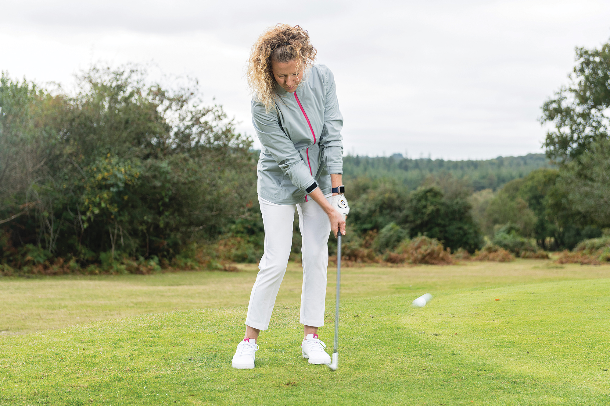 Katie Dawkins demonstrating how to hit a chip shot from off the green without decelerating through impact