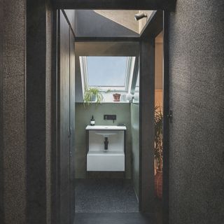 view from a hallway into a loft bathroom in the eaves with slanted walls