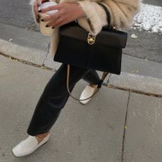 @dawn.tan wears cream loafers with leather trousers, a cream jumper and a black handbag