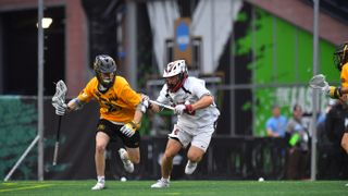  Michael Durnin #21 of the Adelphi University Panthers looks for opening against Harry Boland #70 of the University of Tampa Spartans during the Division II Lacrosse Championship