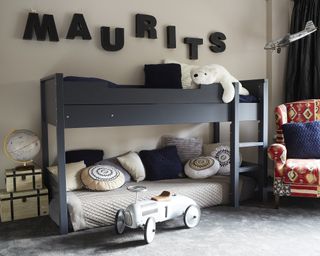 An example of loft bed ideas showing a black loft bed with the lower platform used as a daybed in a neutral room