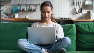 Stimulus check 2 could start next week - here’s what you need to know: Image shows woman sitting on couch using a laptop