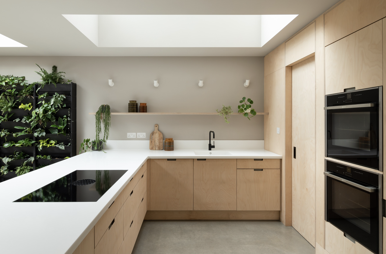 An L-shaped kitchen with a rooflight and plywood fittings