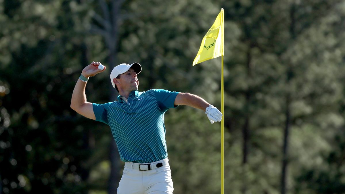 Rory McIlroy of Northern Ireland tosses his ball to the crowd after chipping in for birdie from the bunker on the 18th green to finish his round during the final round of the Masters at Augusta National Golf Club