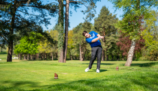 A golfer hits a golf ball with a driver
