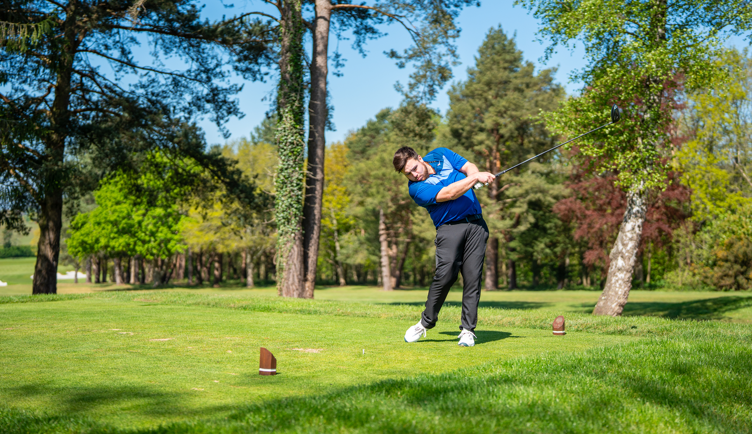 A golfer hits a golf ball with a driver