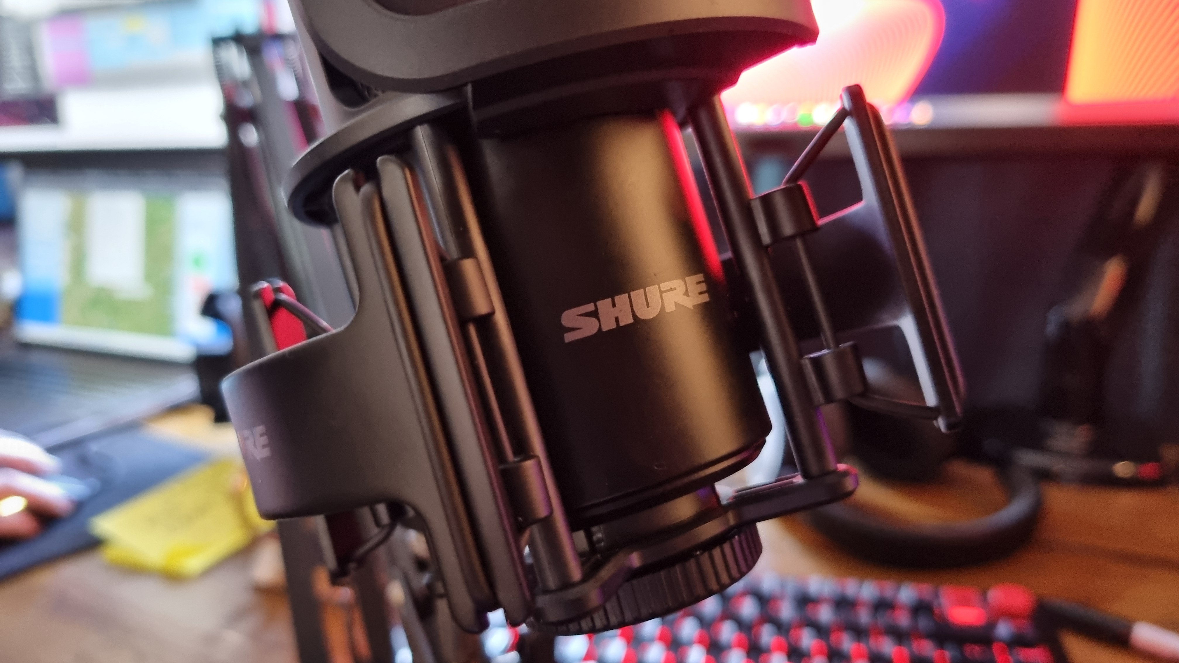 The Shure logo on the front of the Shure SM4 home recording microphone, nestled in its shockmount