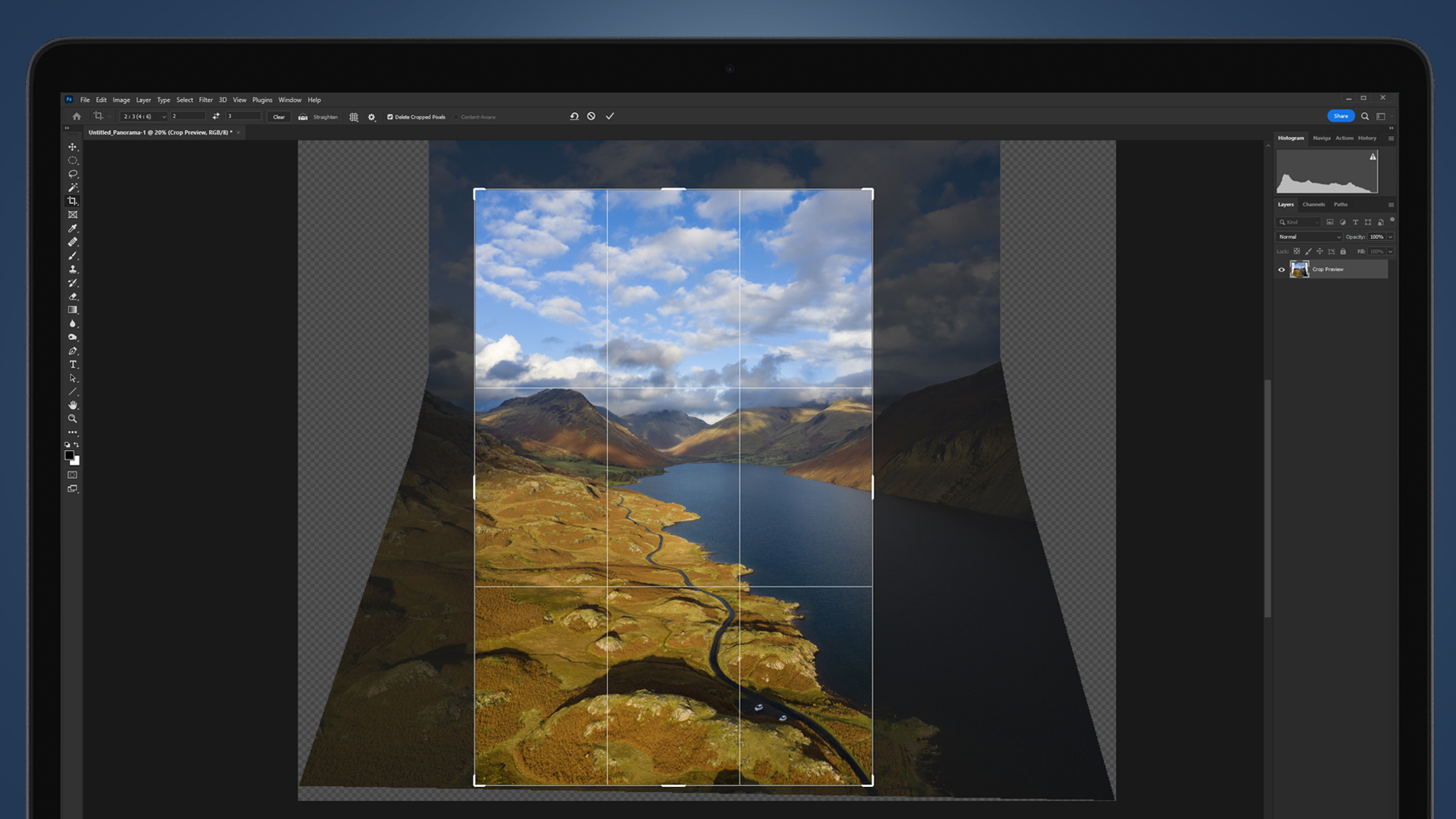 A laptop screen showing a vertical panorama photo being made in Photoshop