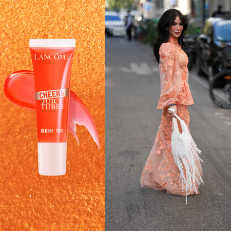 A woman wearing an orange dress and holding a white bag is looking over her shoulder. She is next to a bottle of orange blush.