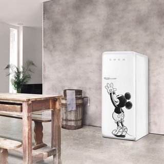 room with grey wall smeg mickey mouse fridge and wooden table