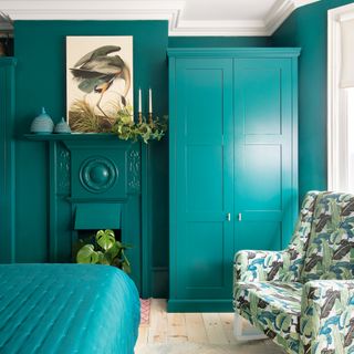 Bedroom with walls, fireplace and wardrobes all painted turquoise