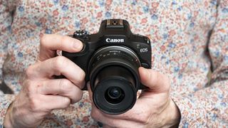 Canon EOS R100 camera in the hand