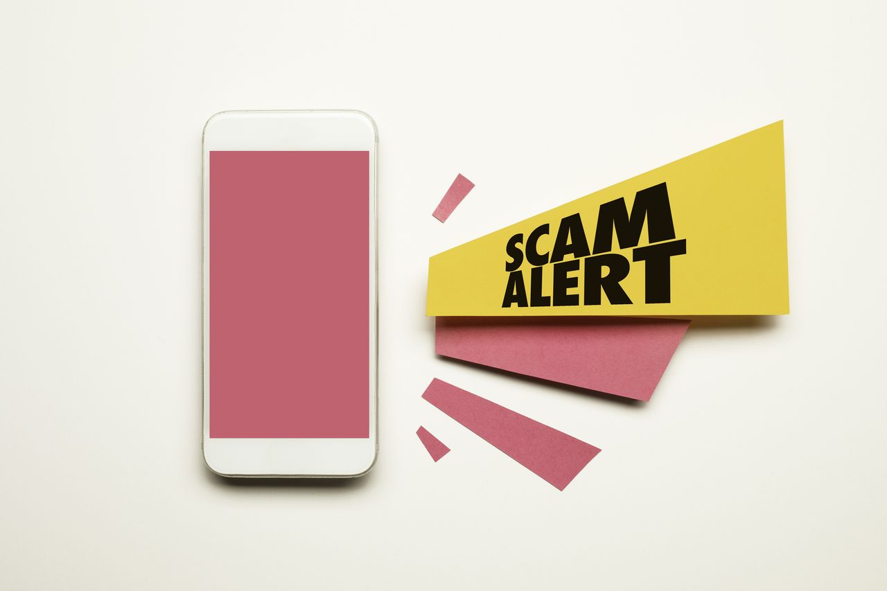 scam alert next to cell phone