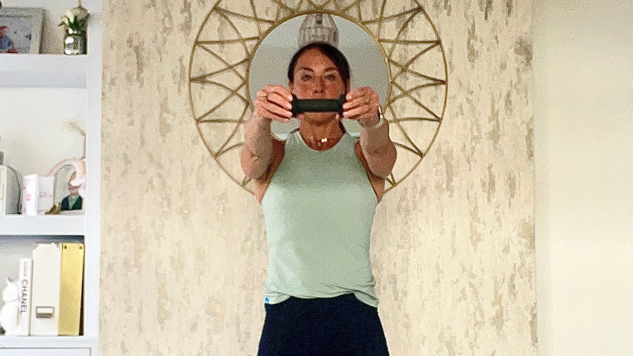 Lucy Miller performing standing oblique twists while holding a dumbbell