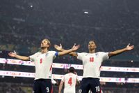 Harry Kane and Jude Bellingham stood with their arms out wide.