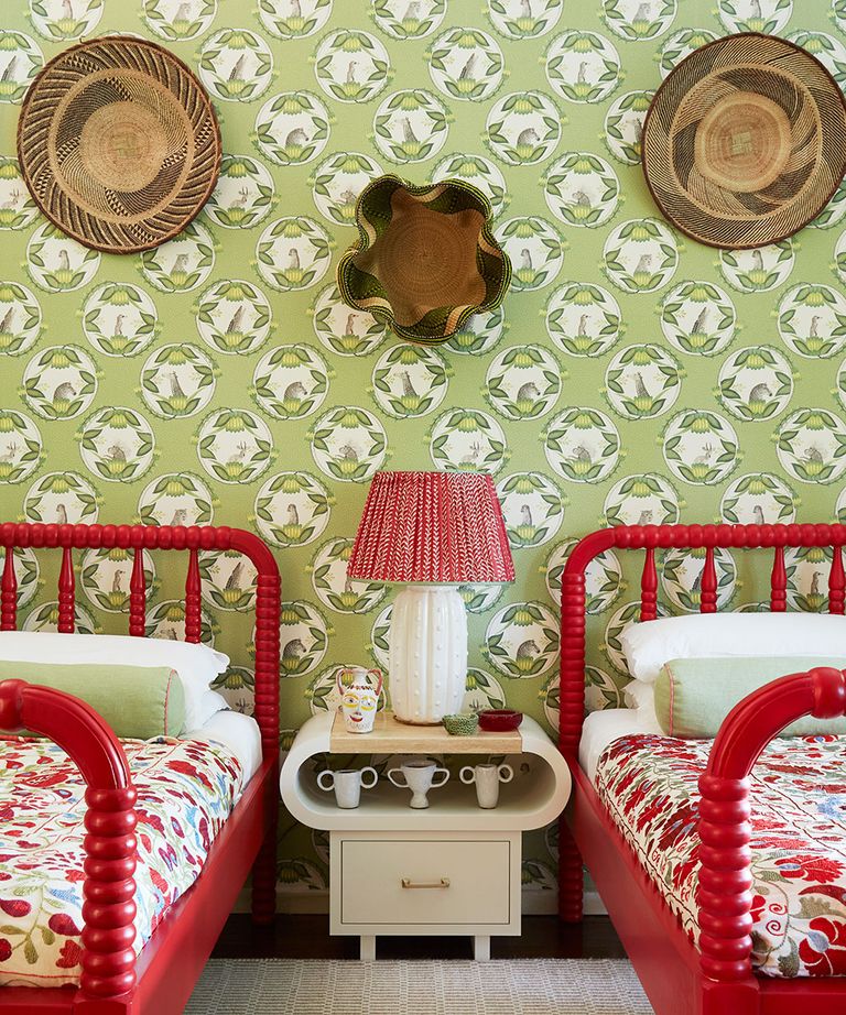 卧室里有两张单人床，漆成红色和绿色图案的墙纸
