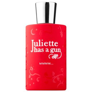 Juliette Has a Gun Mmmm… perfume in red circular bottle embossed with floral design topped with silver metallic cap on white background 