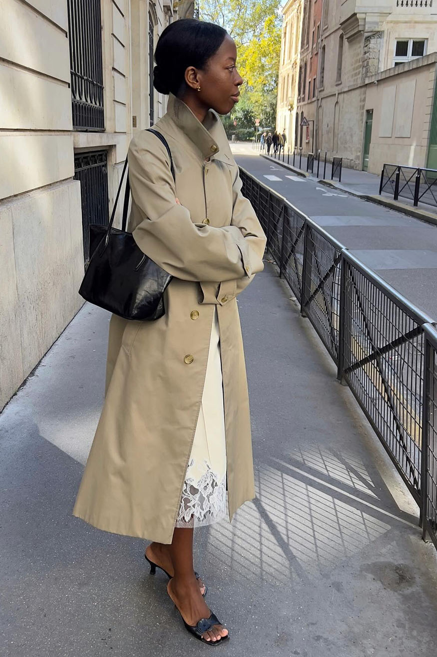 A woman wearing trench coat and a knee-length skirt