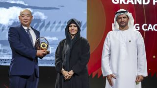 Photograph of HIPA Sustainability grand prize winner Liping Cao of China receiving his trophy from Her Highness Sheikha Latifa bint Mohammed bin Rashid Al Maktoum (left) and HIPA Secretary General His Excellency Ali Khalifa Bin Thalith Al Humairi