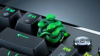 A Razer artisan keycap, made up of three green resin-cast snakes, attached to a gaming keyboard