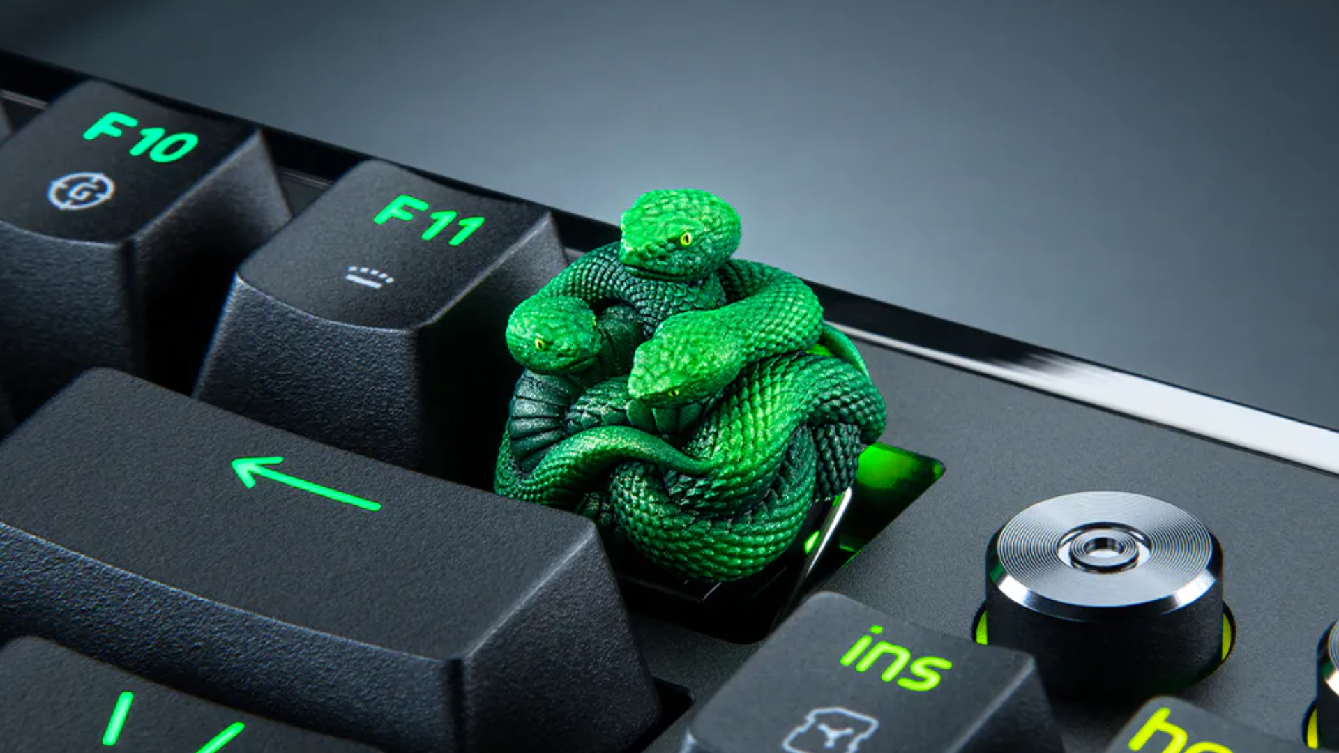 A Razer artisan keycap, made up of three green resin-cast snakes, attached to a gaming keyboard