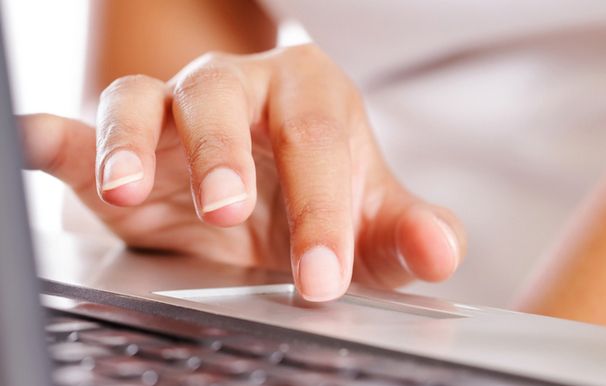 Stock image of person using laptop touchpad