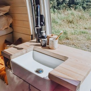 sink area with wooden sink top and toothbrush holder