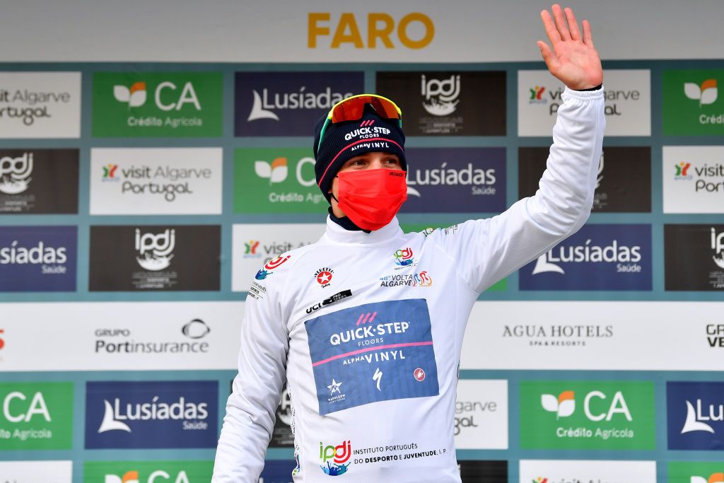 FARO PORTUGAL FEBRUARY 18 LR Remco Evenepoel of Belgium and Team QuickStep Alpha Vinyl celebrates winning the white best young jersey on the podium ceremony after the 48th Volta Ao Algarve 2022 Stage 3 a 2114km stage from Almodvar to Faro VAlgarve2022 on February 18 2022 in Faro Portugal Photo by Luc ClaessenGetty Images