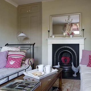 living room with hot pink floral cushions and grey fire place