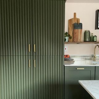 green kitchen cupboards with gold handles
