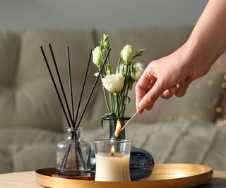 Candle, diffuser, and flowers on a table