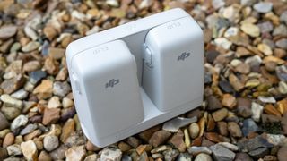 A white battery charging hub on a multi-dark coloured stone background