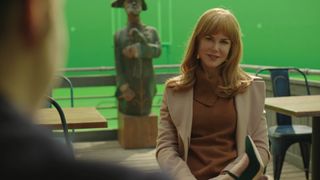 Nicole Kidman sitting on a green screen cafe set