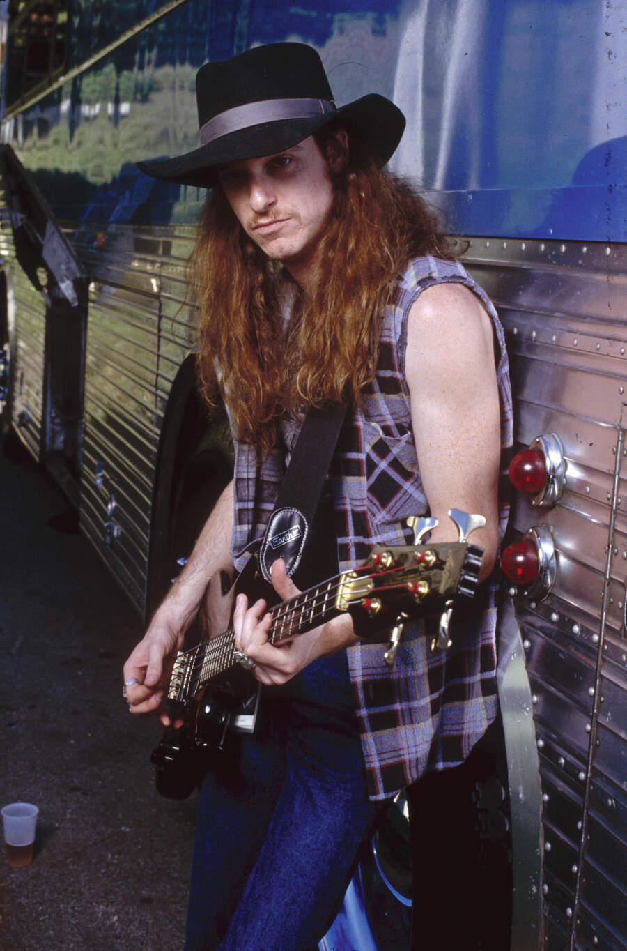 Cliff Burton with bass guitar, next to Metallica's tour bus