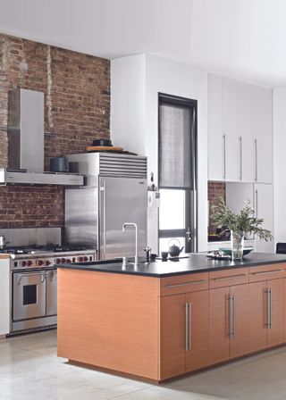 A kitchen with a wooden island and stainless steel fittings