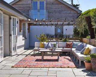 Neutral outdoor seating area with colorful cushions in Cornish coastal new build