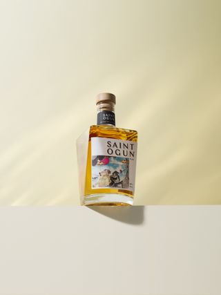 Rum in glass bottle against beige background